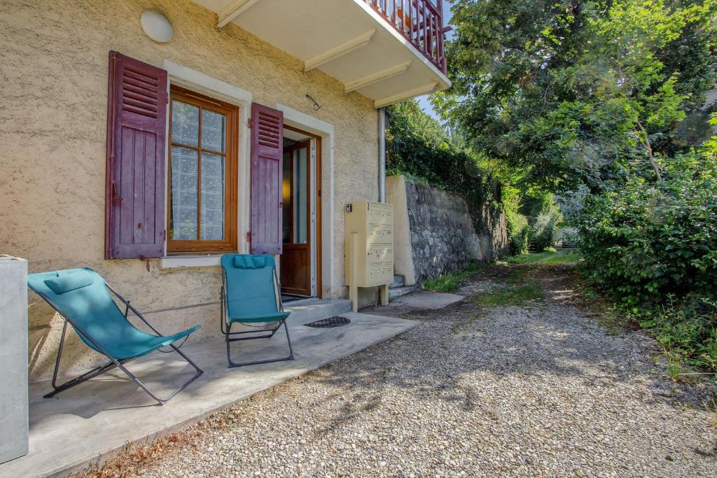 2 chaises bleues assises à l'extérieur d'une maison dans l'établissement Le Nivolet - Studio vue montagne, à Chambéry