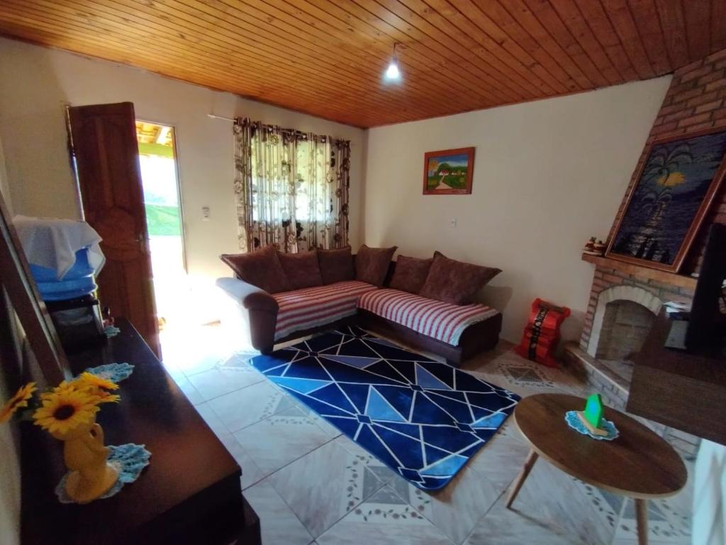 una sala de estar con un sofá y una mesa en Casa Vista Verde, en Camanducaia