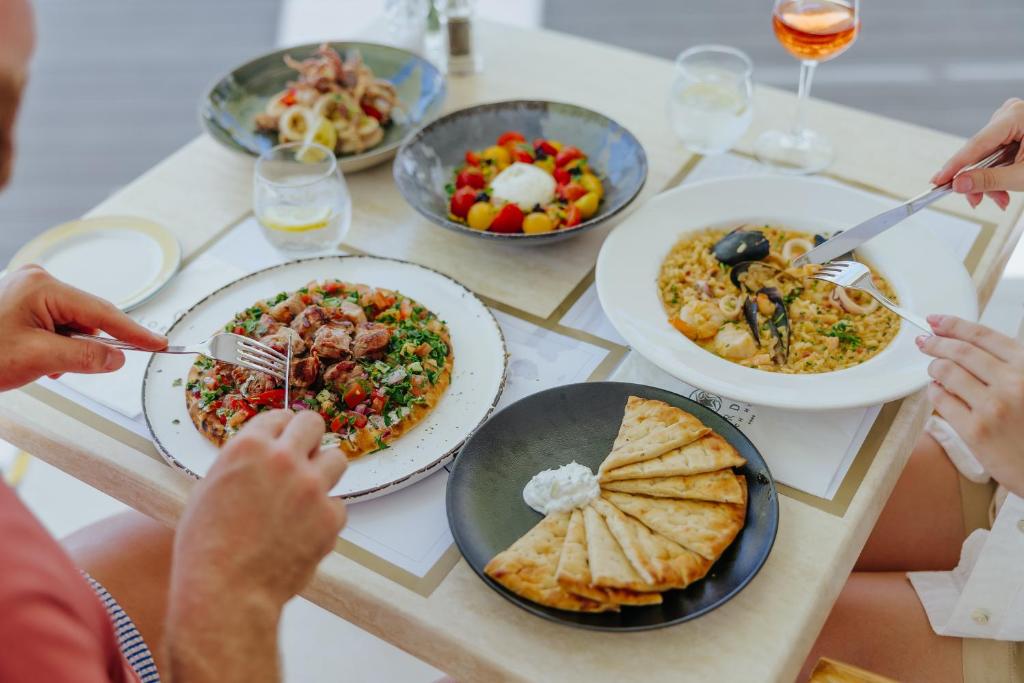 a group of people sitting around a table eating food at Lordos Beach Hotel & Spa in Larnaca