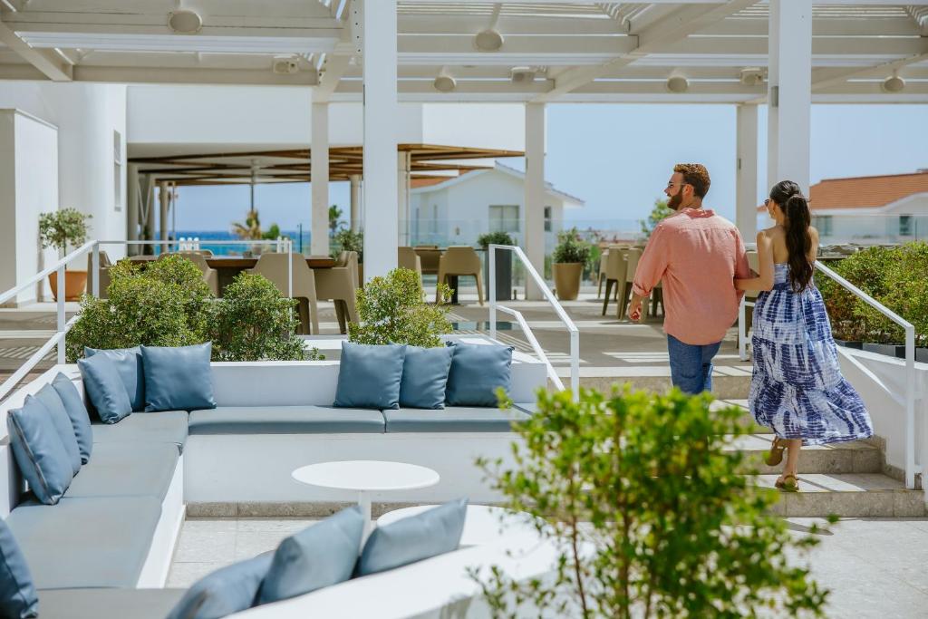 a man and a woman walking on the balcony of a house at Lordos Beach Hotel & Spa in Larnaca