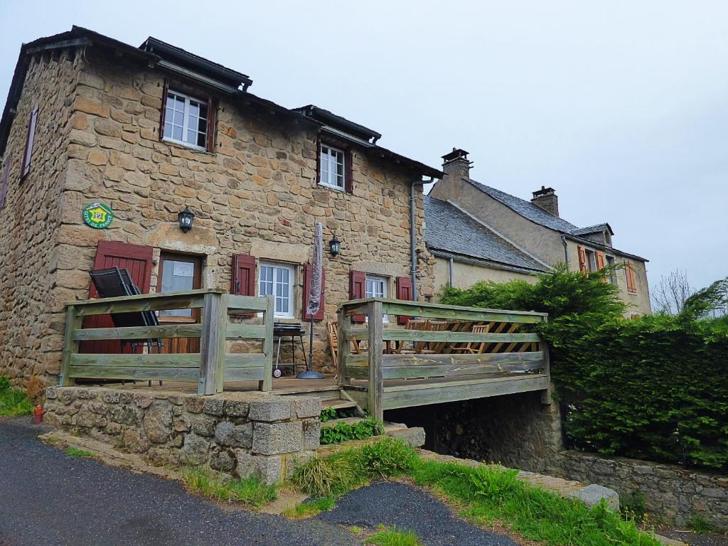 a stone house with a wooden bridge in front of it at Village de gîtes de Sainte-Lucie in Sainte-Lucie