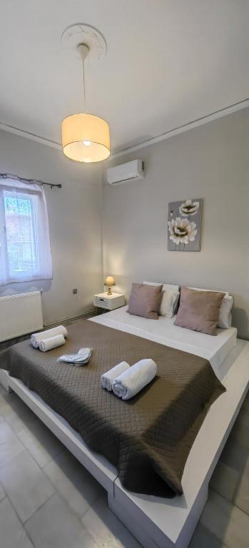 a large bed in a white room with two pillows at Allin home in Mantoúkion