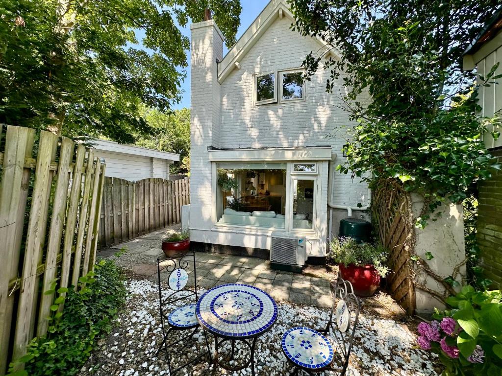 a patio with tables and chairs in front of a house at Vakantiehuis Flori in Bergen
