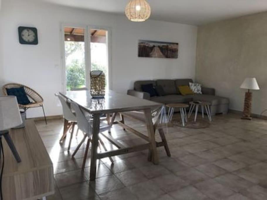 ein Wohnzimmer mit einem Tisch und einem Sofa in der Unterkunft Maison de vacance proche de la plage in La Brée-les-Bains