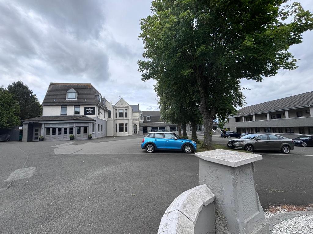 a blue car parked in a parking lot in front of a house at Richmond Park Hotel in Boʼness