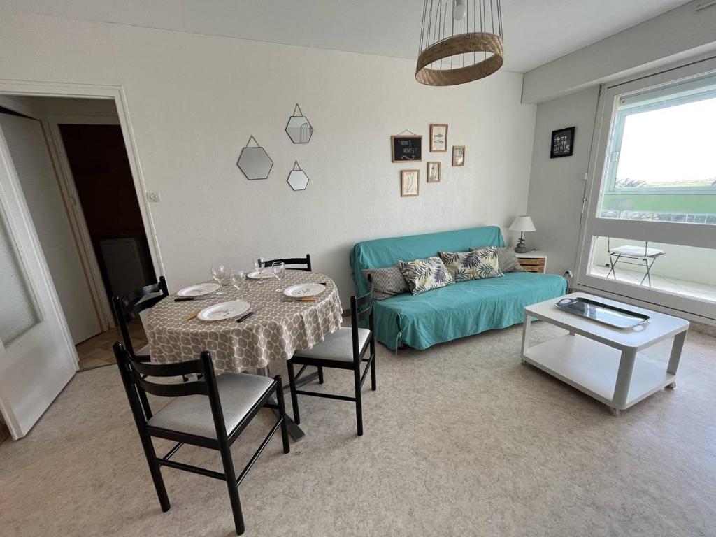 un salon avec une table et un canapé dans l'établissement T2 à 150m de la plage avec loggia, parfait pour 5 pers. - FR-1-324A-37, à Saint-Hilaire-de-Riez