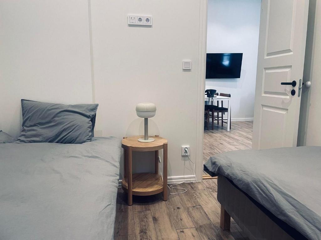 a bedroom with two beds and a table with a lamp at Explore Stockholm Old Town in Stockholm