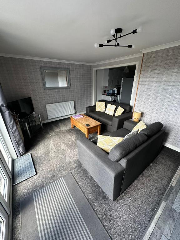 una sala de estar con un sofá y una mesa en Self Catering Spacious 2 Bed Apartment with sea views, en South Erradale