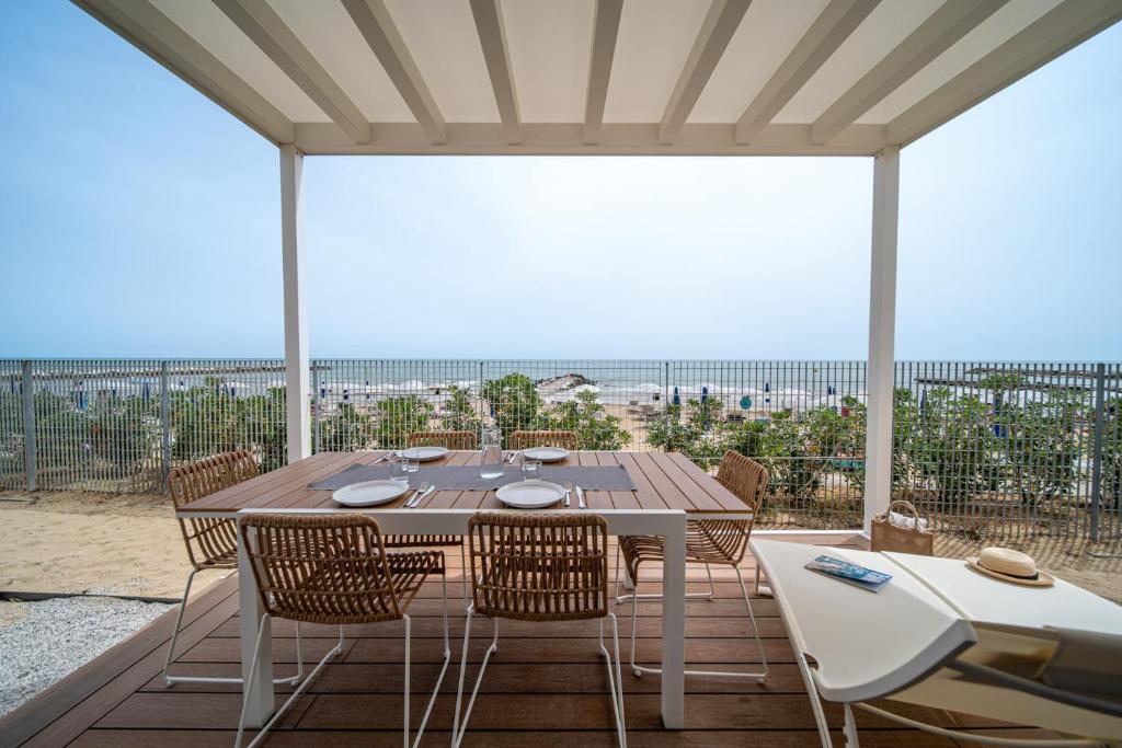 a dining table and chairs on a patio with a view at Villaggio San Francesco in Duna Verde