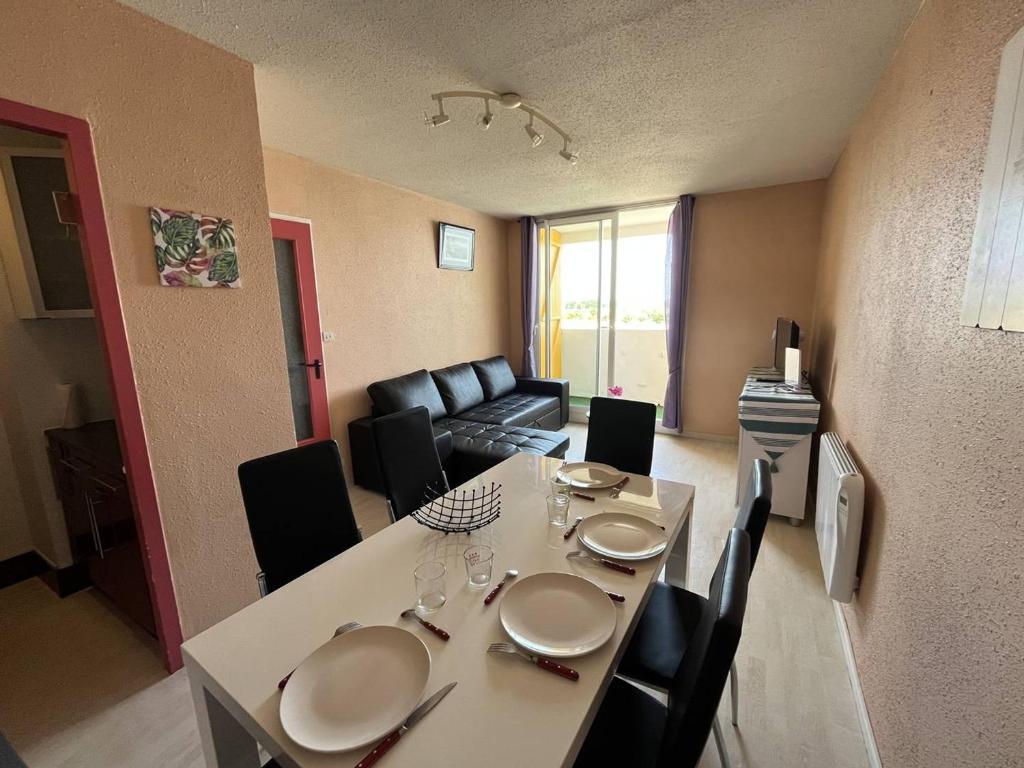 un salon avec une table avec des chaises et un canapé dans l'établissement Charmant Apt Familial 2 Ch. Proche Plage et Commerces - St Hilaire de Riez - FR-1-324A-21, à Saint-Hilaire-de-Riez