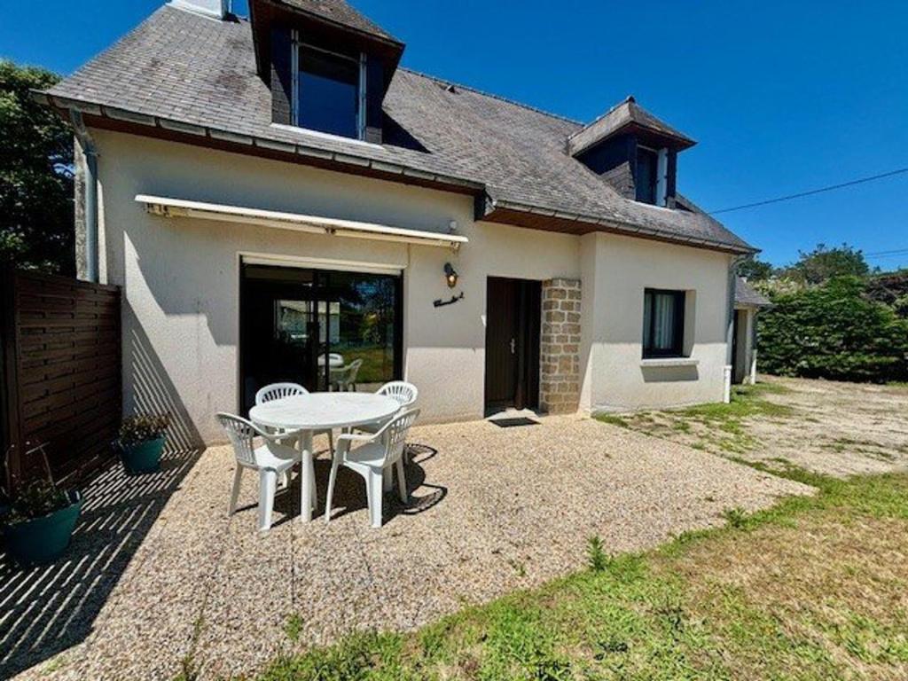 un patio avec une table et des chaises devant une maison dans l'établissement Maison calme 5 pièces à Saint-Pierre-Quiberon, proche plage, jardin clos, pour 8 personnes - FR-1-478-13, à Saint-Pierre-Quiberon