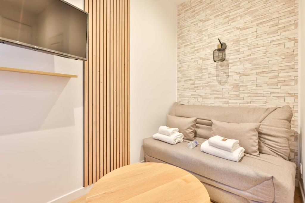 - un salon avec un canapé et des serviettes dans l'établissement Cozy studio in the heart of the 9th arrondissement, à Paris