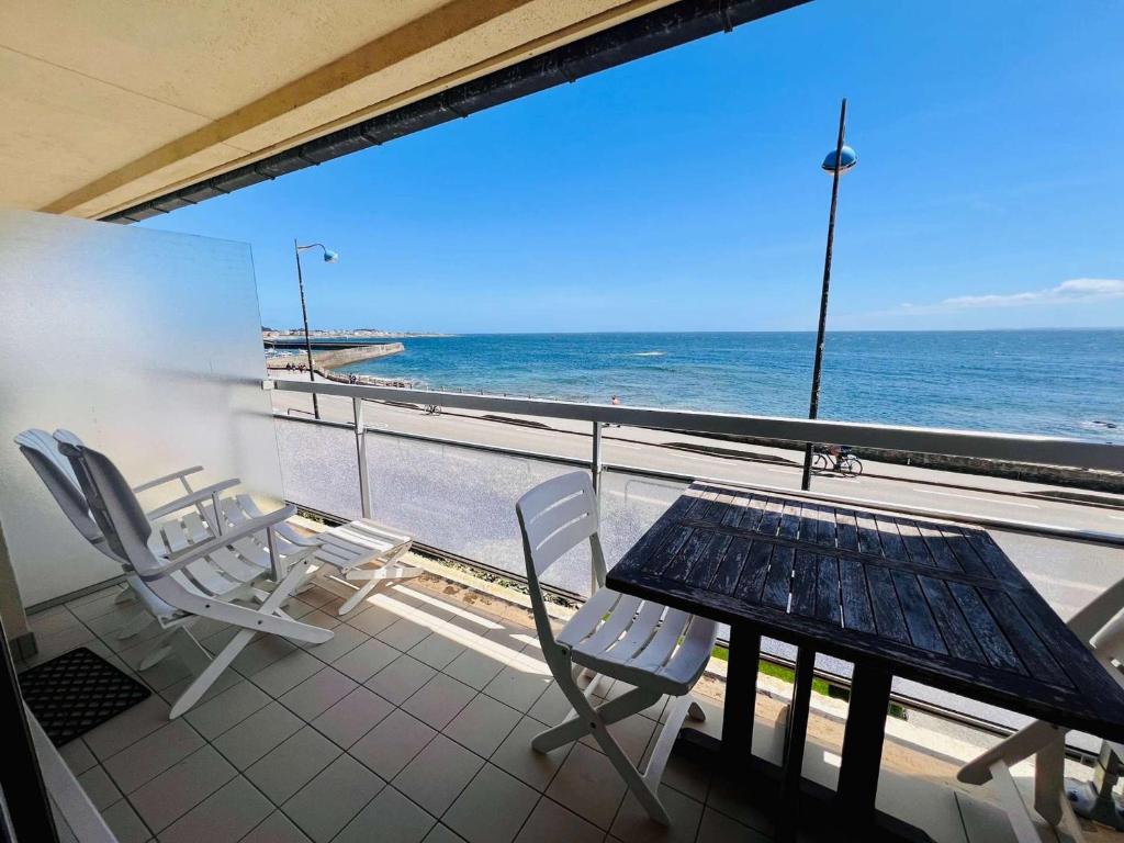 un balcon avec une table et des chaises et l'océan dans l'établissement Quiberon - agréable 2 pièces avec vue sur le château, parking, animaux admis - FR-1-478-9, à Quiberon