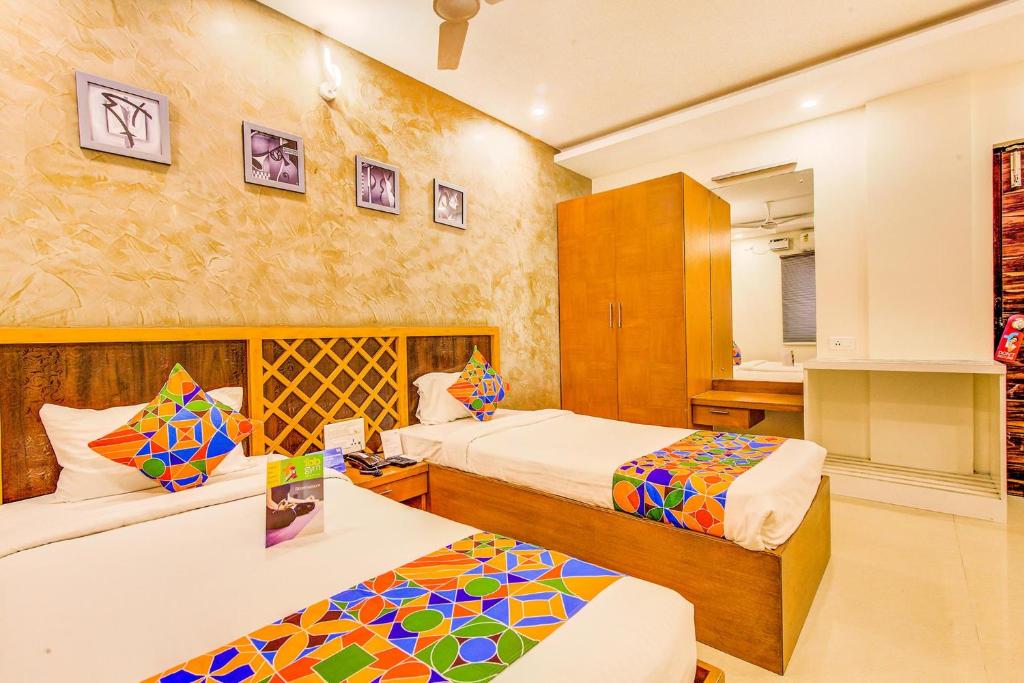 a hotel room with two beds and a bathroom at FabExpress Mayuri Residency in Bangalore