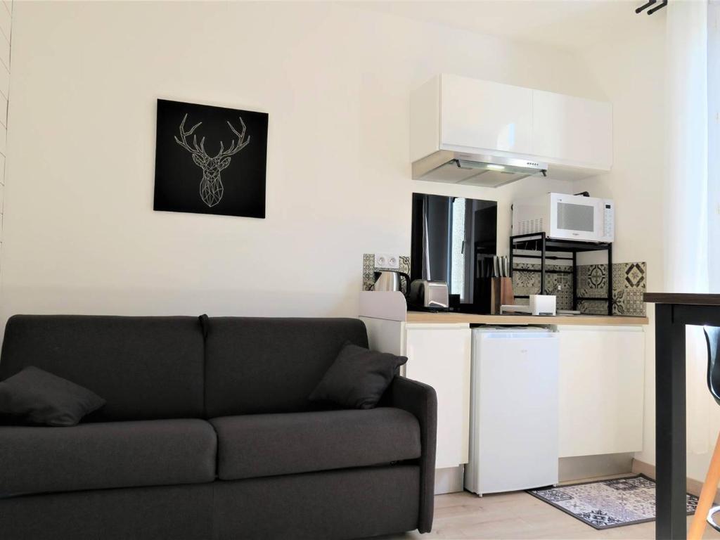 un salon avec un canapé et une cuisine dans l'établissement Studio rénové avec WIFI, à 400m de la plage, centre de Trégastel - FR-1-368-299, à Trégastel