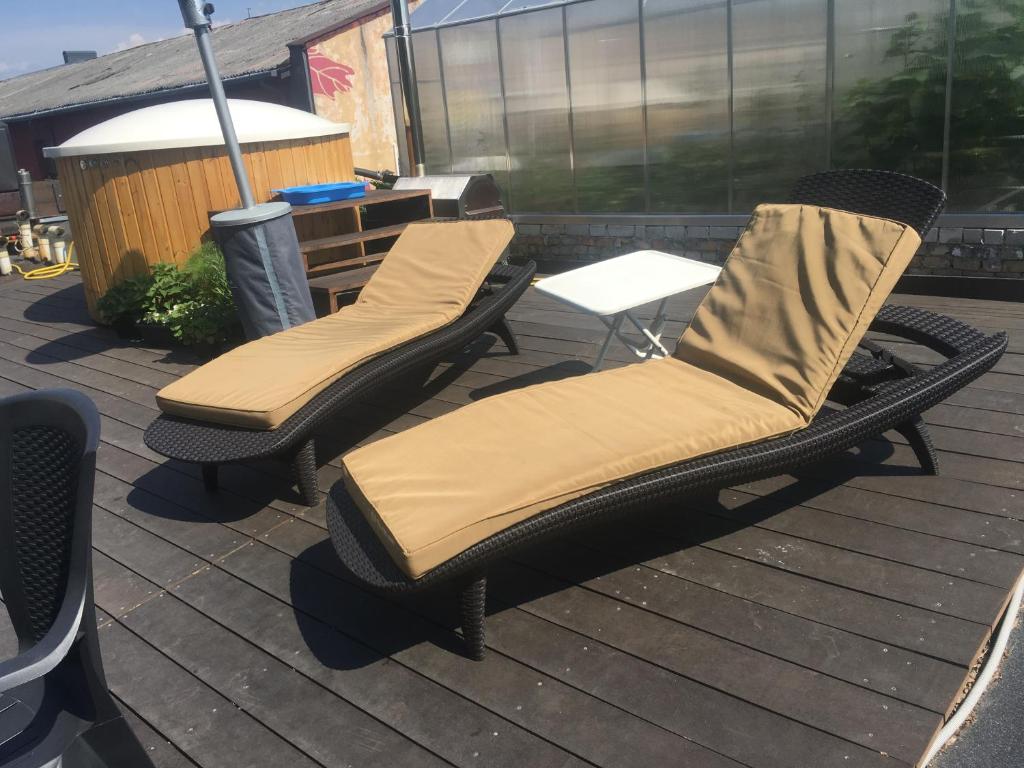 two wicker chairs sitting on top of a deck at Rooftop terrace Green Sky in Vilnius