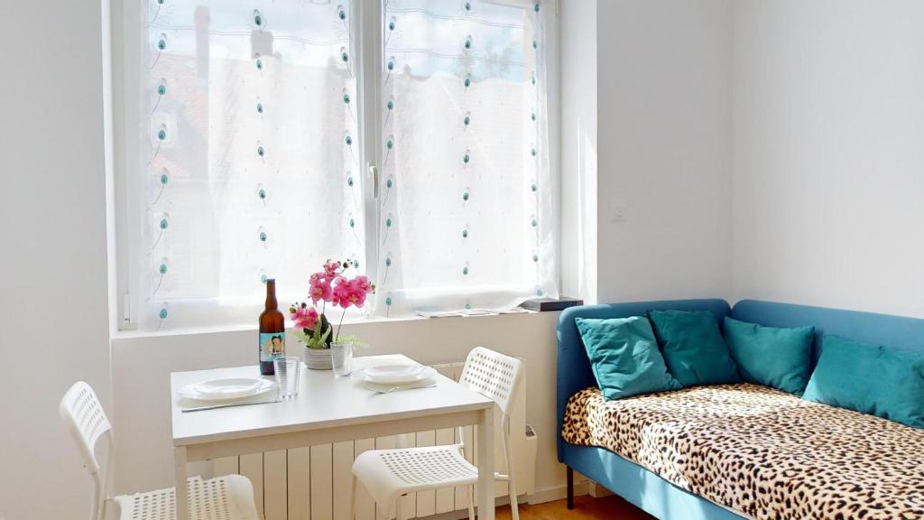 un salon avec un canapé bleu et une table dans l'établissement Le Charme Colmarien - Appartement 2 pièces au cœur de la ville, à Colmar