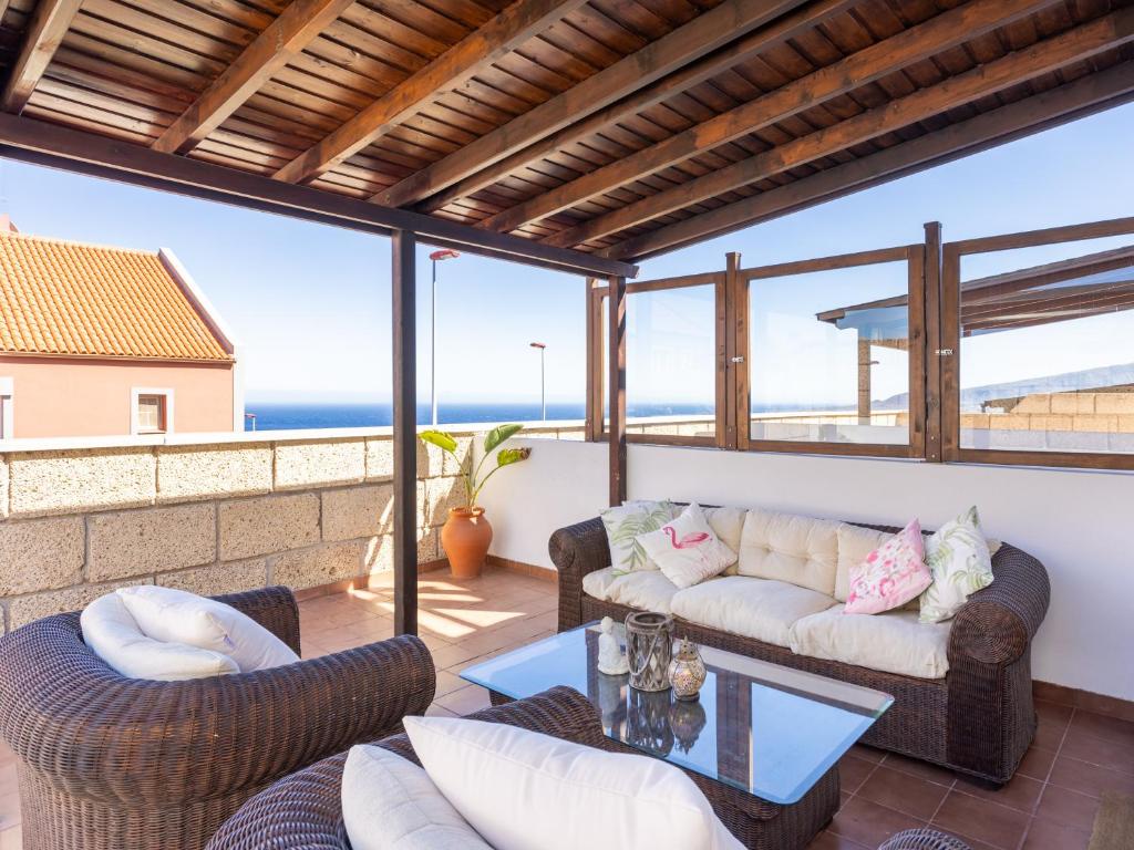 a patio with a couch and chairs on a balcony at Live Barranco Hondo Crisanto in Candelaria