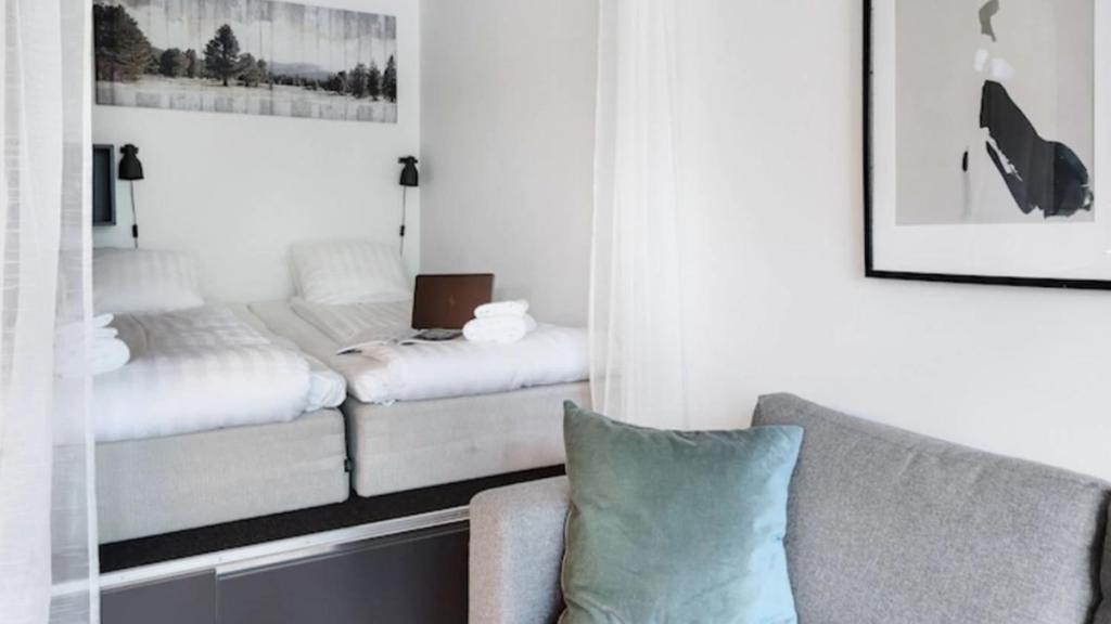 a room with a bed and a couch and a chair at HOOM Home & Hotel Sollentuna in Sollentuna