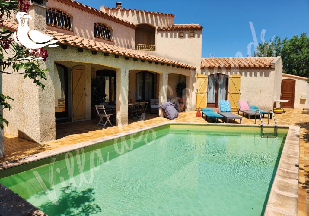 une image d'une piscine en face d'une maison dans l'établissement La villa des goélands, au Barcarès