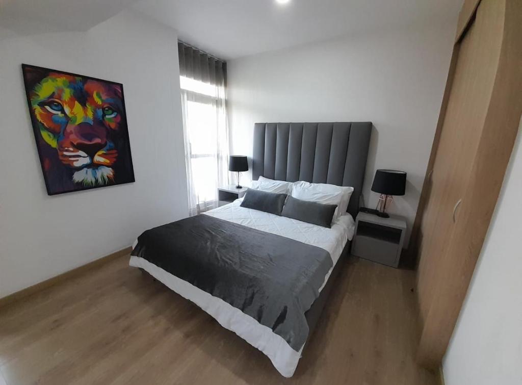 a bedroom with a bed and a painting on the wall at HERMOSO y CÓMODO APARTAESTUDIO SABANETA in Sabaneta