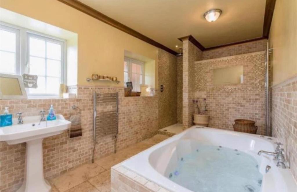 a large bathroom with a tub and a sink at Rodgers Land (The Bungalow) in Boston