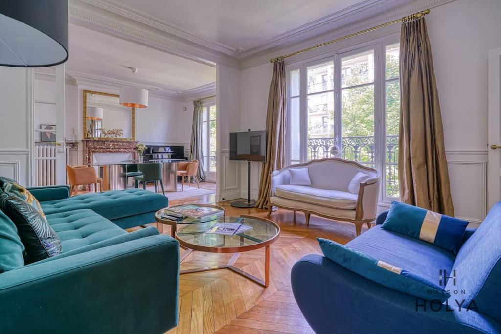 un salon avec des canapés bleus et une table dans l'établissement Le Royal - À deux pas de Paris - 249C, à Courbevoie