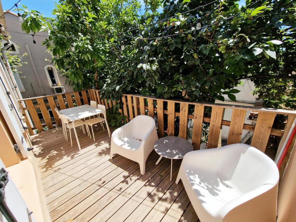 une terrasse avec des chaises, des tables et un arbre dans l'établissement GregBnb - CLIMATISE - T2 Terrasse 38m2 - WiFi, à Toulon
