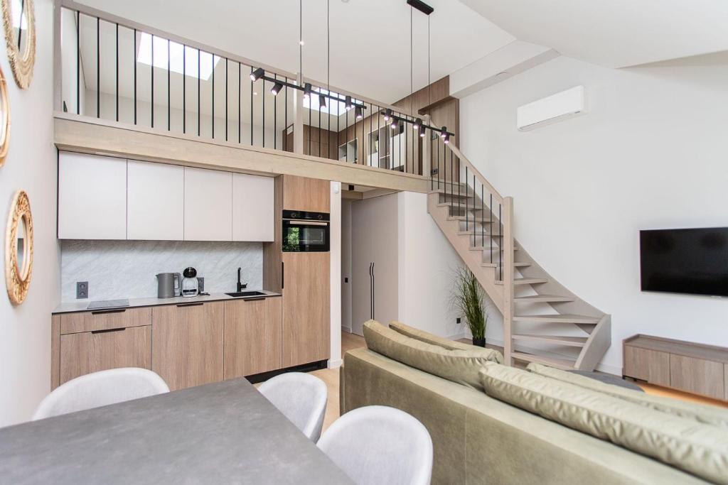 a dining room with a staircase and a table and chairs at LEX apartments in Palanga