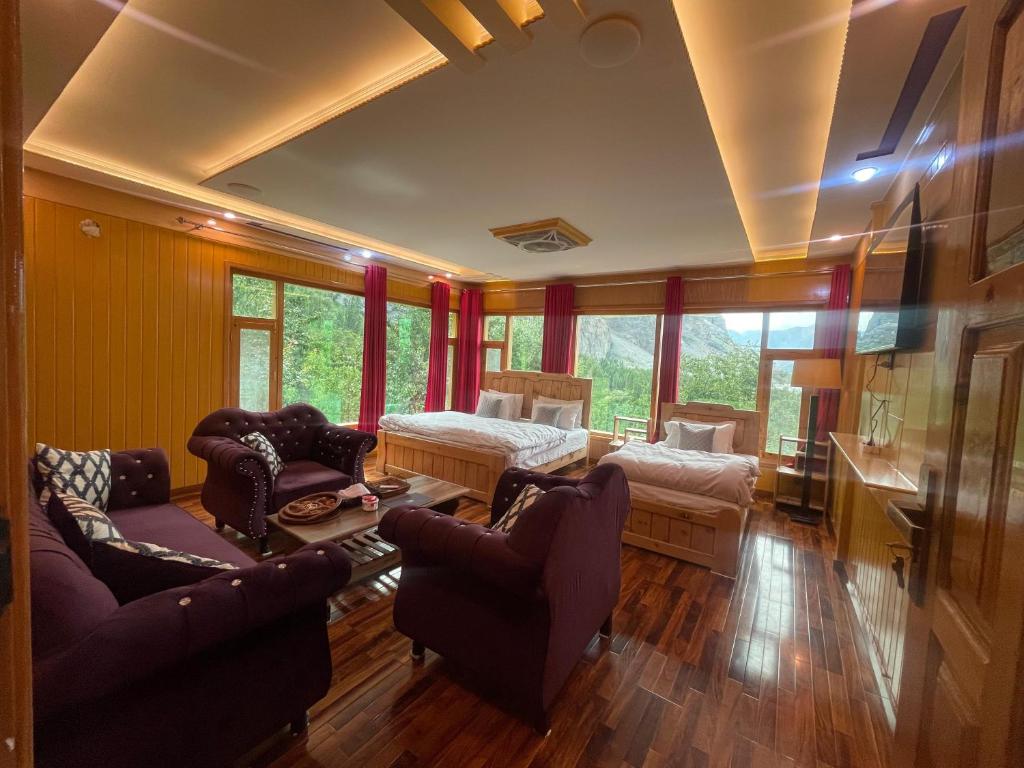a living room with a bed and a couch and chairs at North Palace Khaplu in Khaplu