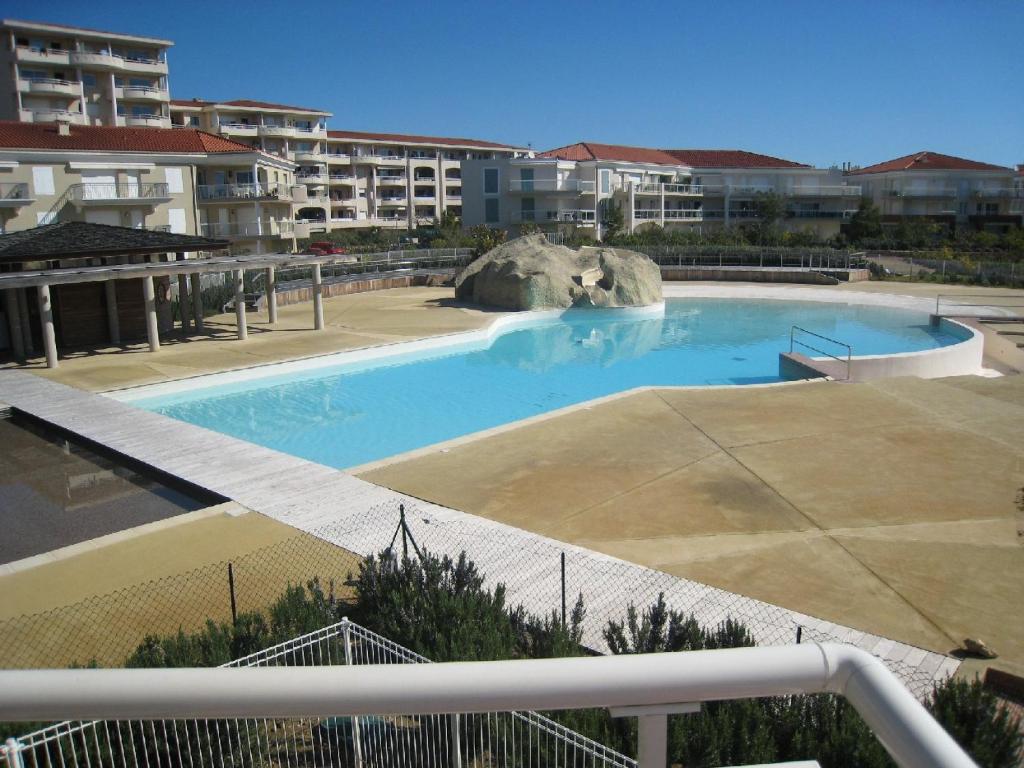 une grande piscine devant certains immeubles d'habitation dans l'établissement Beachside apartment with sea view, à Antibes