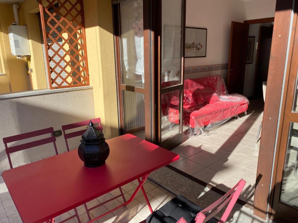 a red table and chairs in a room with a couch at Mimosa in Acquaseria