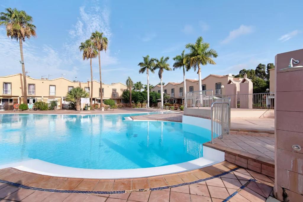 Una gran piscina con palmeras y casas. en Be Room Oasis Harmony, en Maspalomas