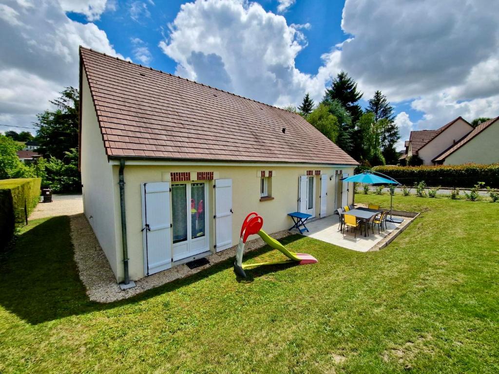 une petite maison avec une cour et une aire de jeux dans l'établissement Gîte Basilic, à Saint-Aignan