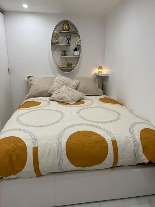 - un grand lit dans une chambre blanche avec un grand couvre-lit dans l'établissement Studio indépendant Disney-Vallée, à Gretz-Armainvilliers