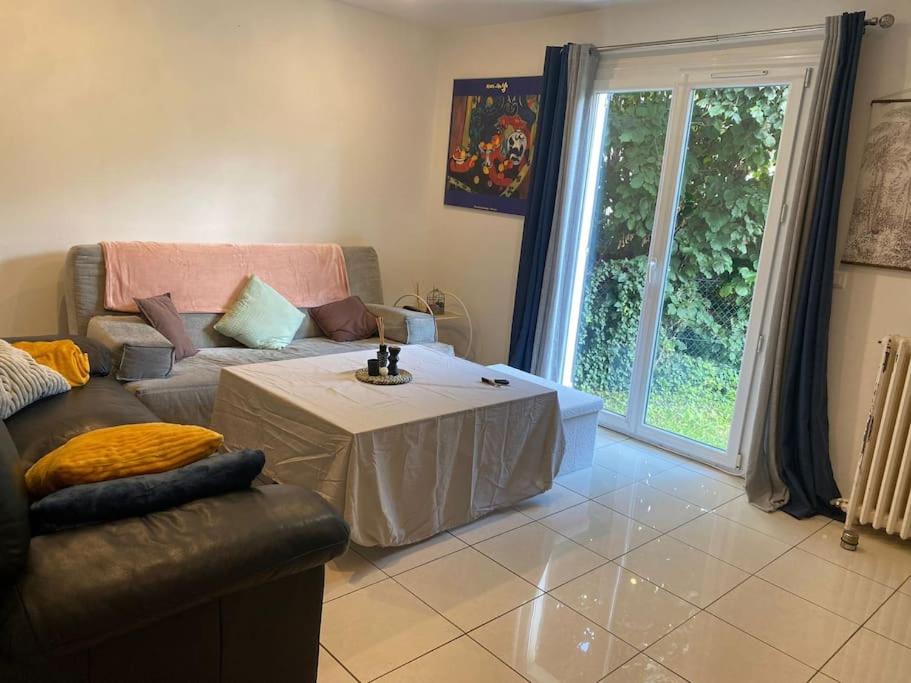 un salon avec un canapé et une table dans l'établissement Charmante Maison Familiale près de Paris, à Drancy