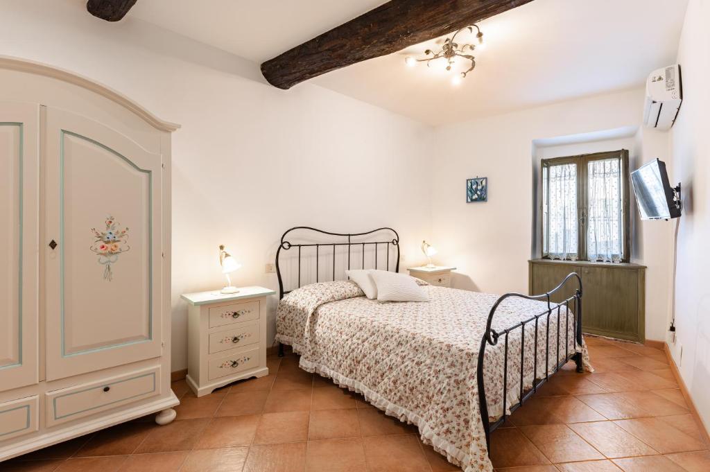 a bedroom with a bed and a dresser and a window at Green Home in Ronciglione