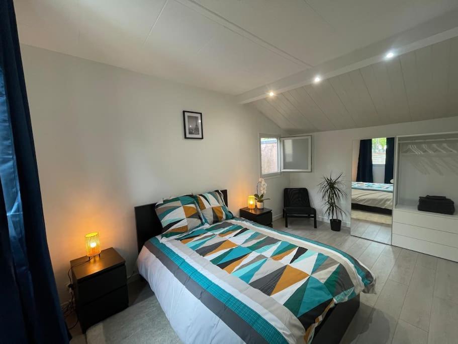 une chambre avec un lit et un salon dans l'établissement Maison paisible, élégante Aulnay-sous-Bois CDG JO, à Aulnay-sous-Bois