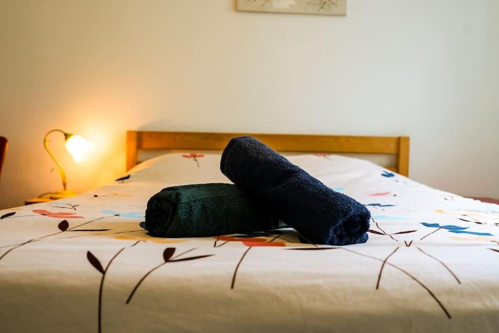 Una cama con dos toallas y una bolsa encima. en Appartement La Gare Viotte, en Besançon