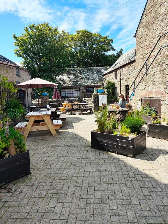 a patio with tables and picnic tables in a building at St Margaret's Hope Backpackers Hostel in Orkney