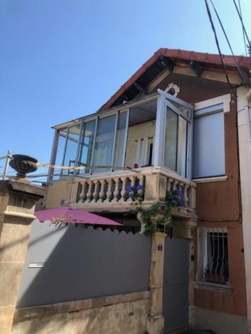 un bâtiment avec un balcon au-dessus dans l'établissement la ruche des abeilles, à Avignon