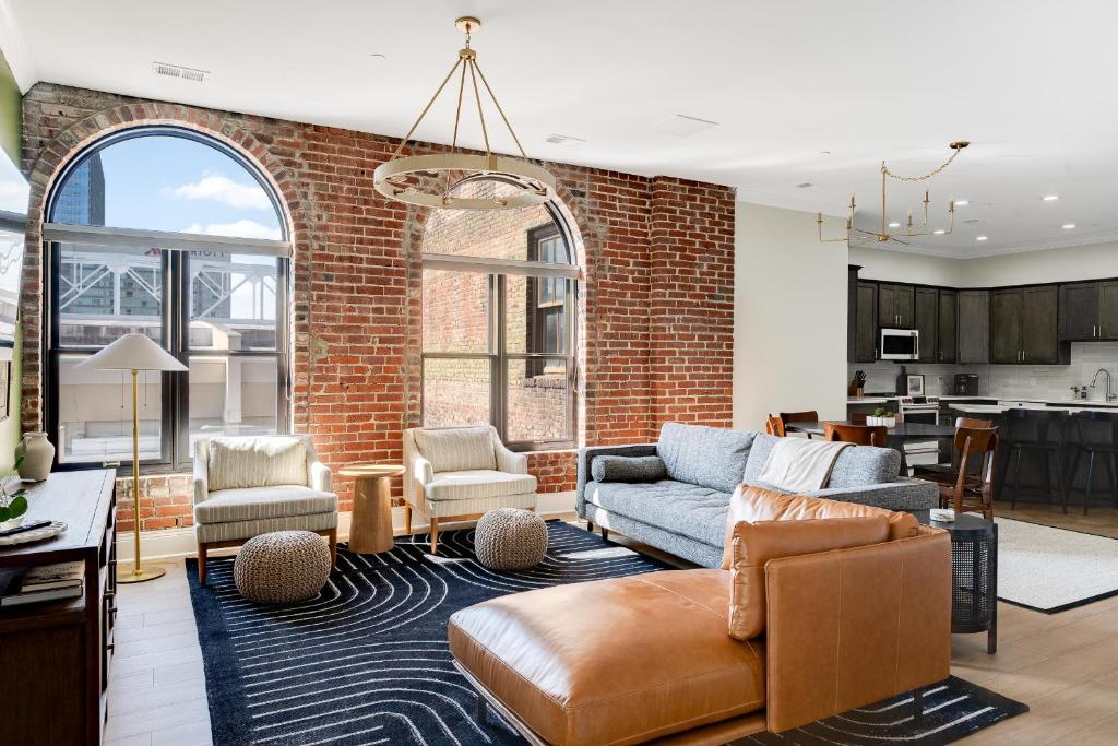 an open living room with a brick wall at Top Floor Penthouse at the Historic Levy Building in Louisville