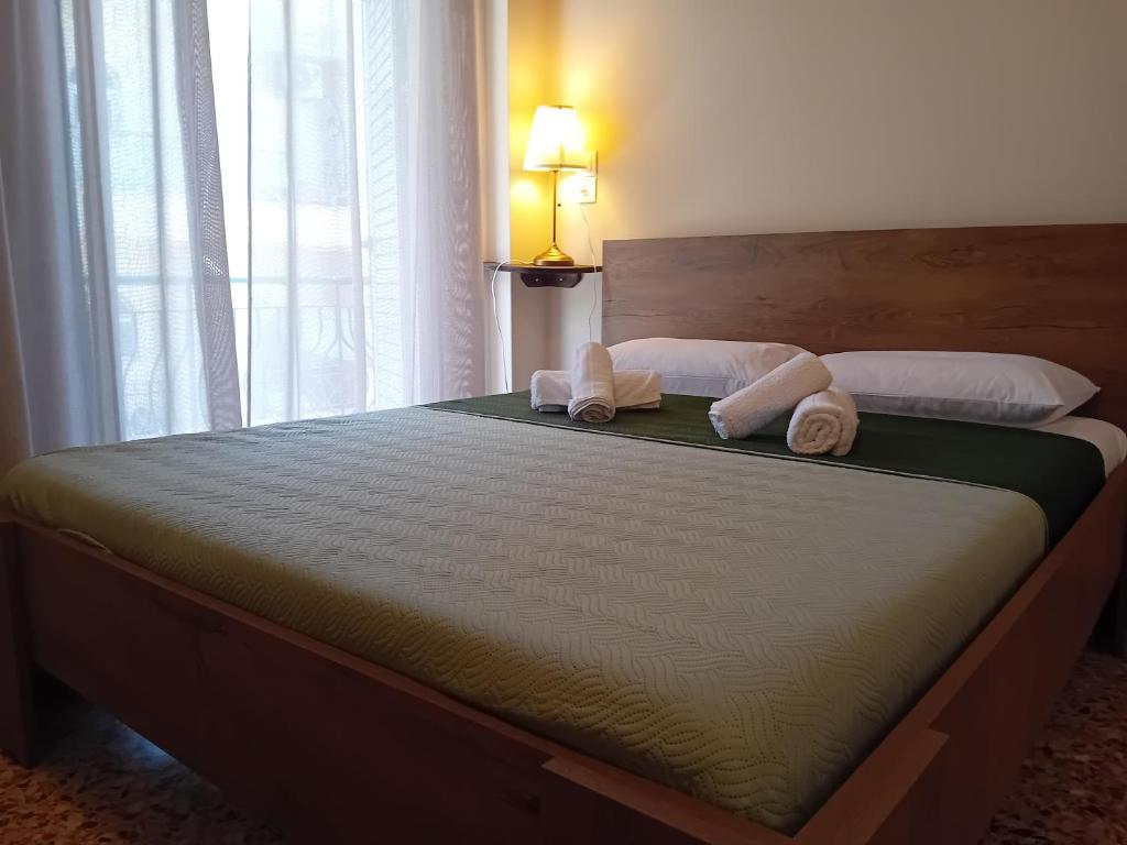 a bedroom with a large bed with towels on it at Rigas Apartment in Artemida