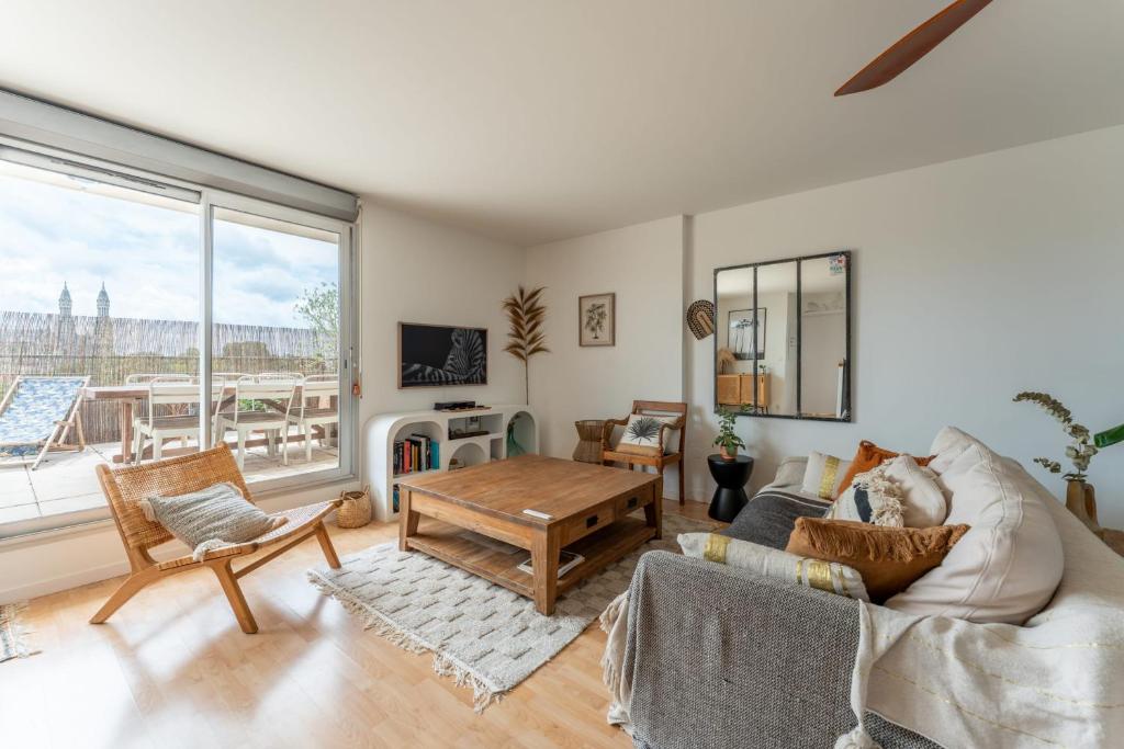 un salon avec un canapé et une table dans l'établissement Appartement Duplex Andréia - Welkeys, à Bordeaux