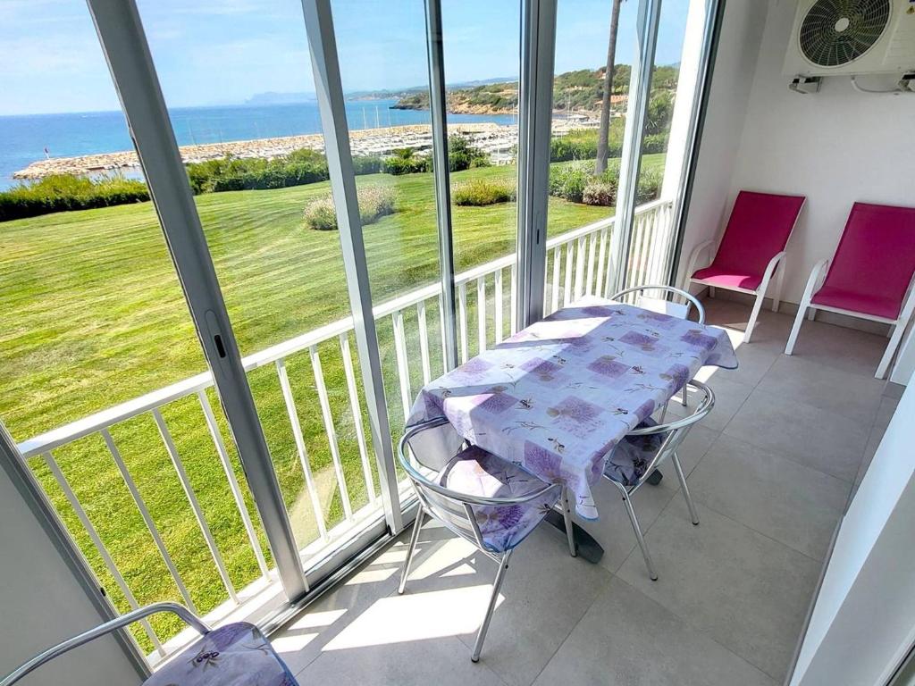 une table et des chaises sur un balcon avec vue sur l'océan dans l'établissement T3 climatisé avec piscine, tennis et parking à 200m des plages - FR-1-316-252, à Six-Fours-les-Plages
