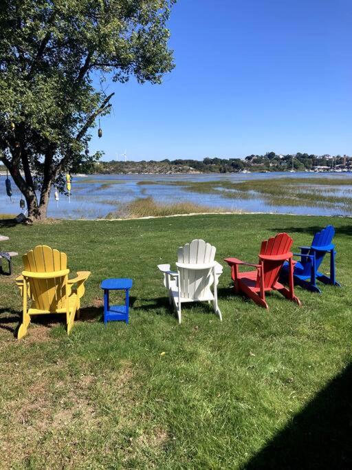a group of colorful chairs and tables in the grass at The Buoys in Gloucester