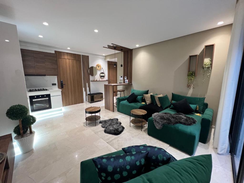 Studio4 Comfortable rest في الدار البيضاء: غرفة معيشة بها كنب أخضر ومطبخ