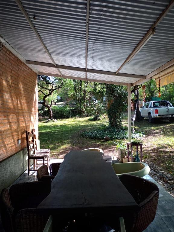 a patio with a table and chairs under a roof at Casa en Villa Los Aromos cerca del río in Villa Los Aromos
