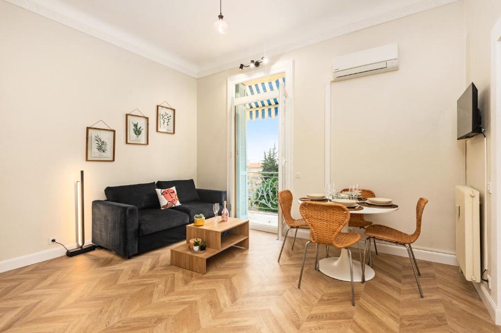 un salon avec un canapé noir et une table dans l'établissement MONT FLEURI- Somptueux 2 pièces - Parking - Menton, à Menton