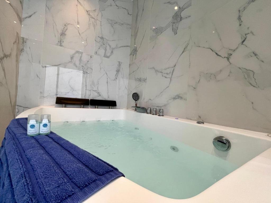 a bathroom with a bath tub with a blue towel at Appartement Romantique - 044 in Rouen